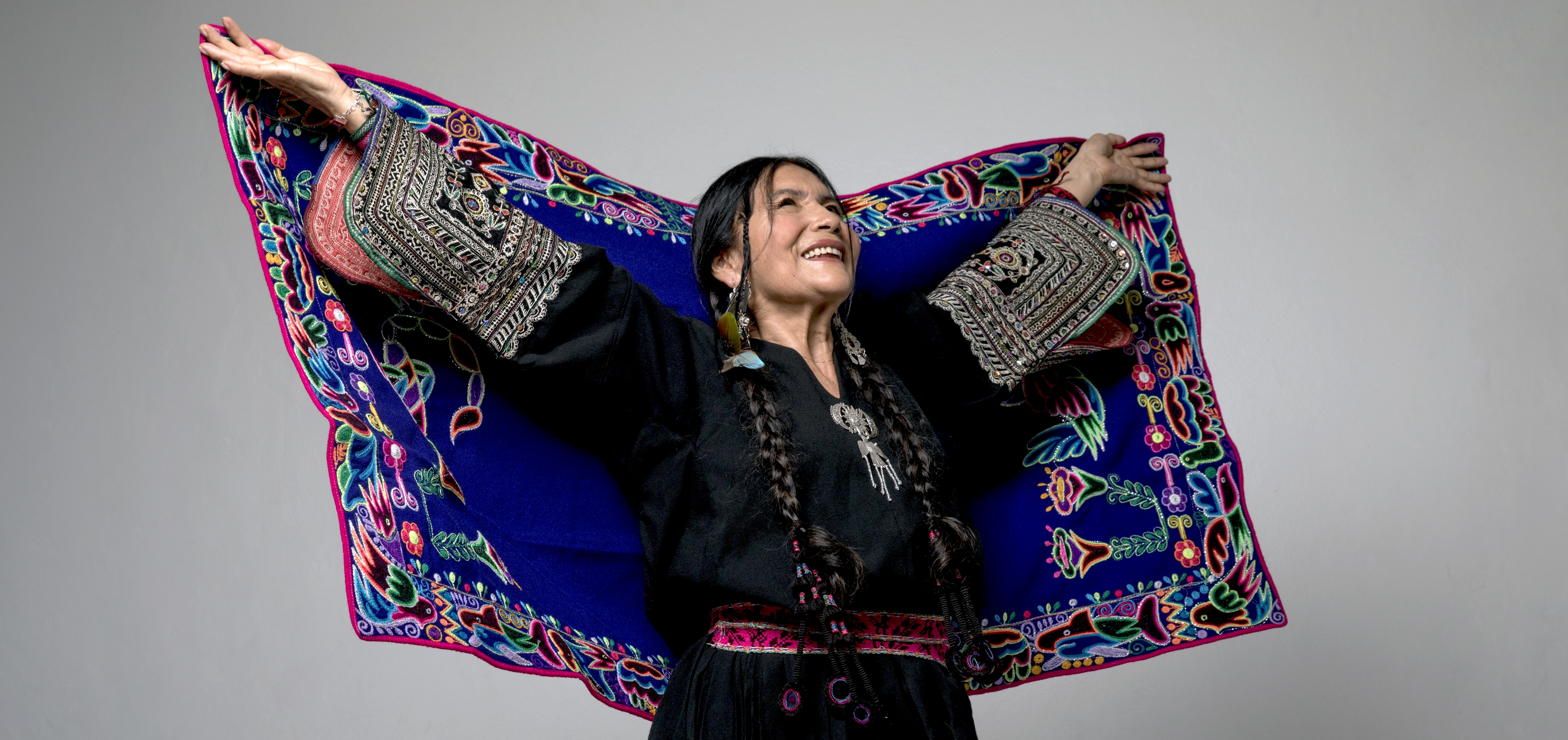 Luzmila Carpio opening her ceremonial textile like wings